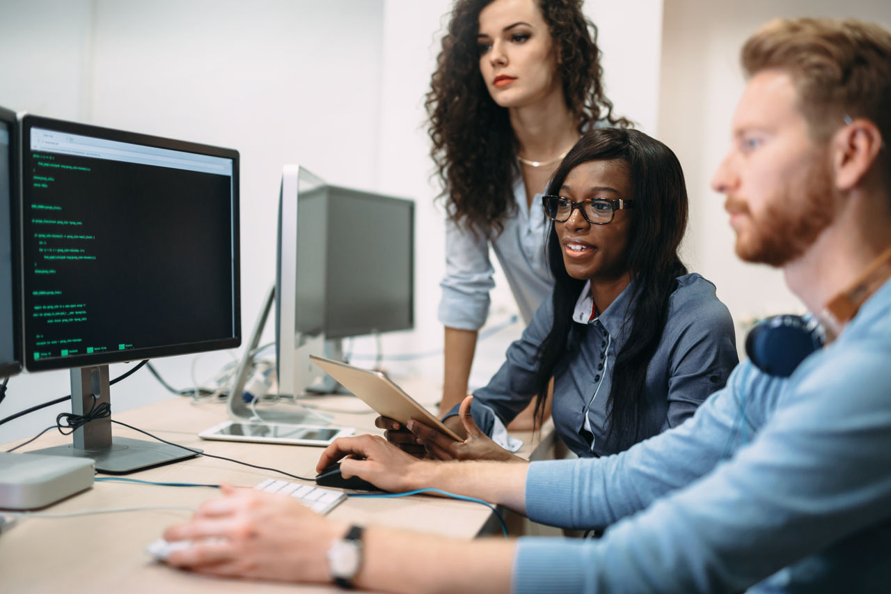 Programmers cooperating at  IT company developing apps